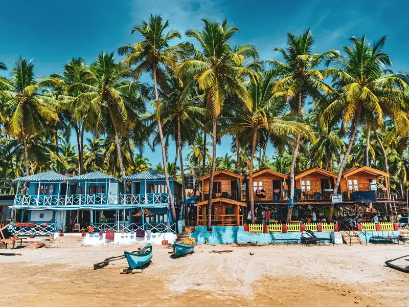 Colorful huts among palm trees on Palolem beach, Goa